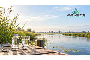 Nederlands kraanwater in een glas met materiaal voor waterkwaliteitscontrole op de achtergrond.