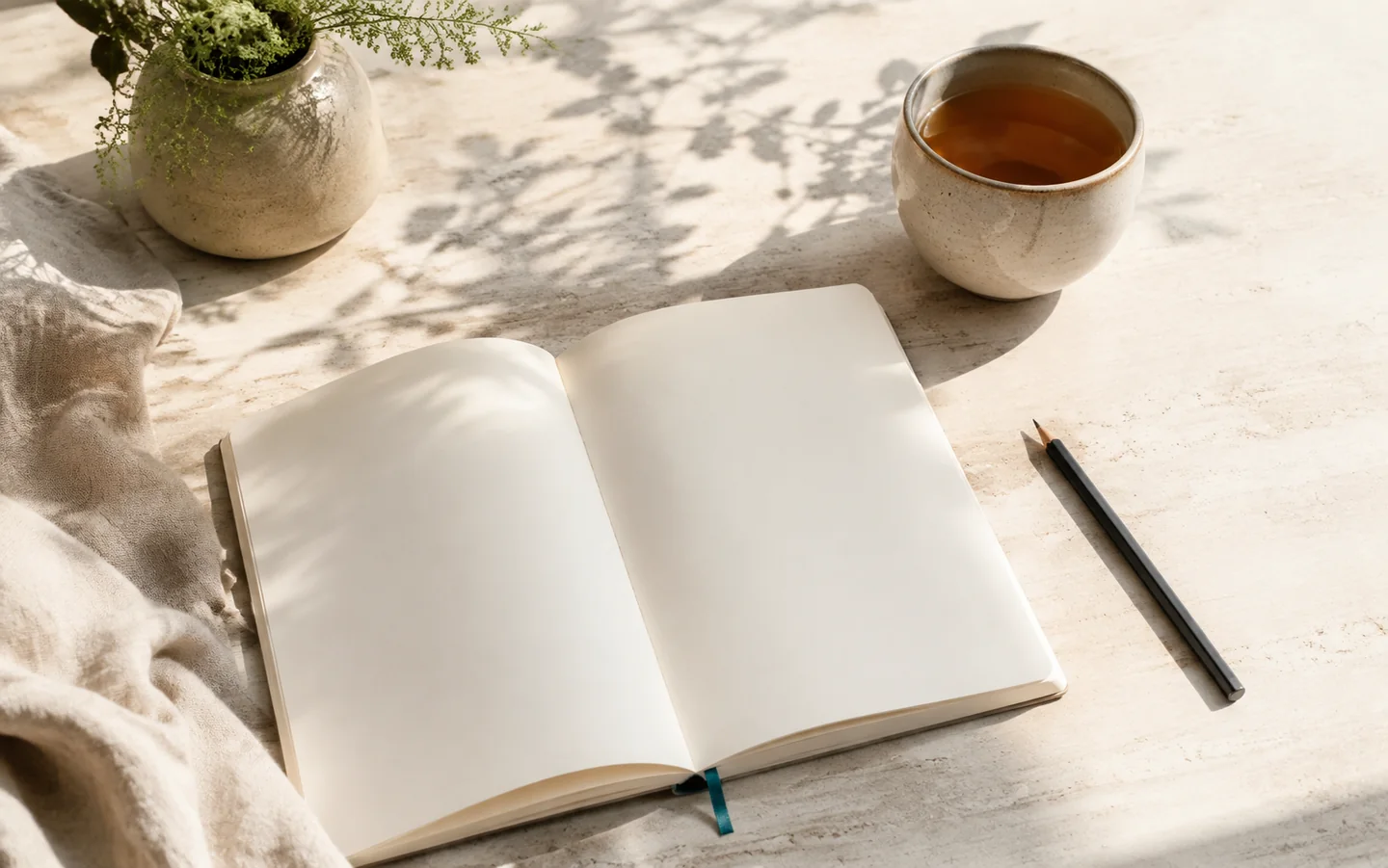 Journal abierto, lápiz y té con luz de mañana